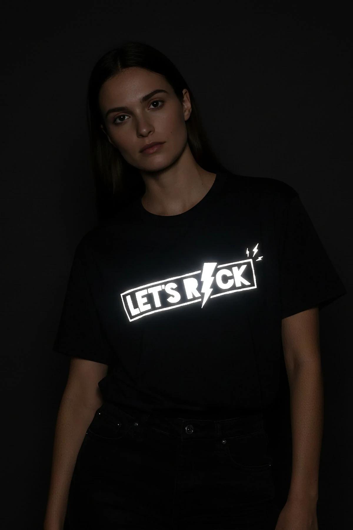 Flaş altında beyaz parlayan Let's Rock şimşek baskılı siyah reflektör grafik tişört