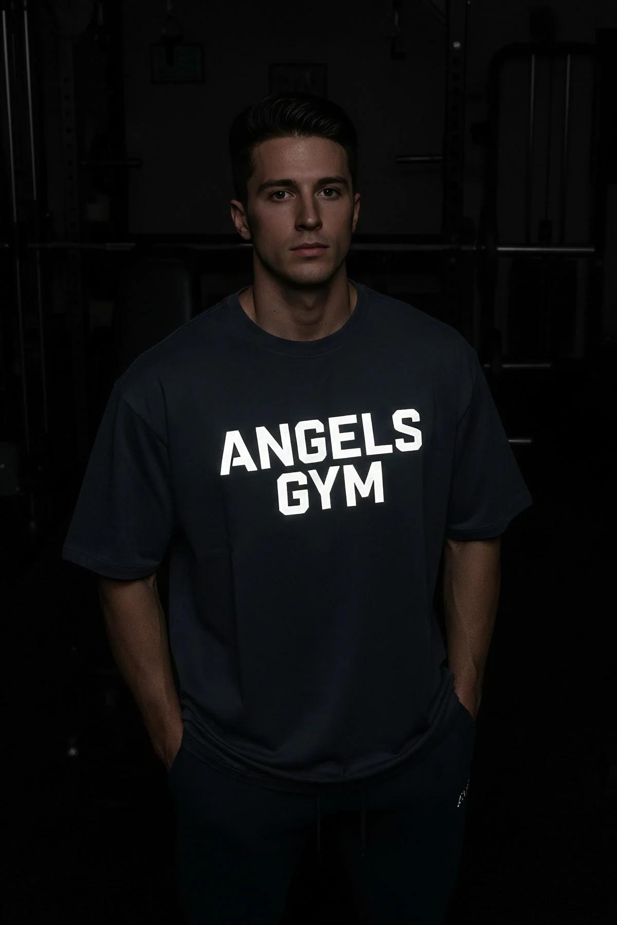 Siyah pamuklu tişört göğsündeki reflektör beyaz ANGELS GYM logo baskısının yakın çekimi