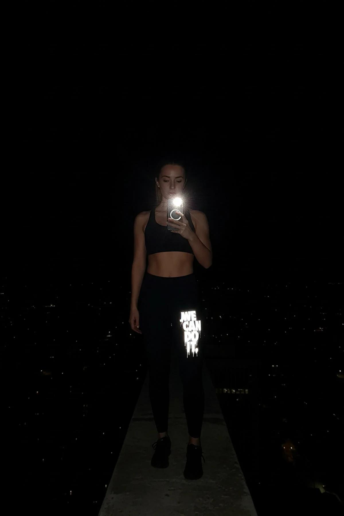 Siyah reflektör baskılı tayt ve siyah spor sütyen ile gece açık hava egzersiz kıyafeti
