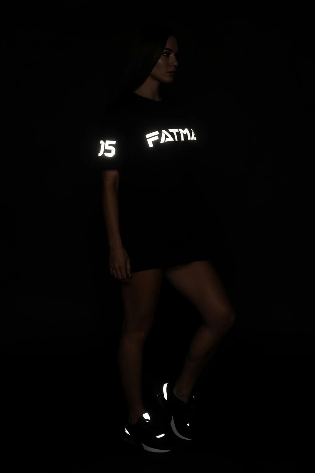 Kadın modelde düşük omuz silüetiyle reflektör FATMA 05 grafikli oversize siyah tişört