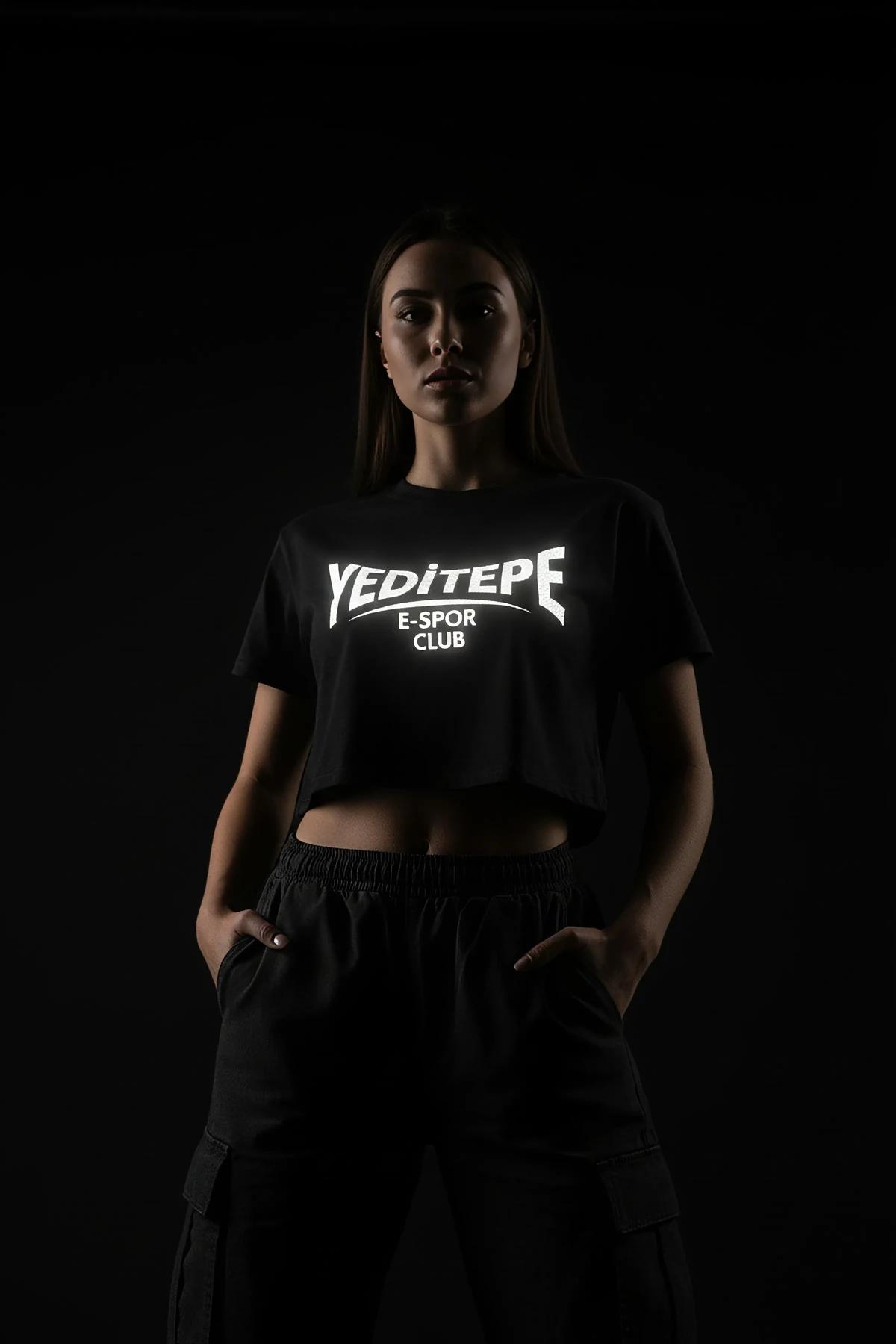 Doğrudan ışık altında aktive olan siyah pamuk jersey crop tişörtteki reflektör esport kulüp logosunun yakın çekimi