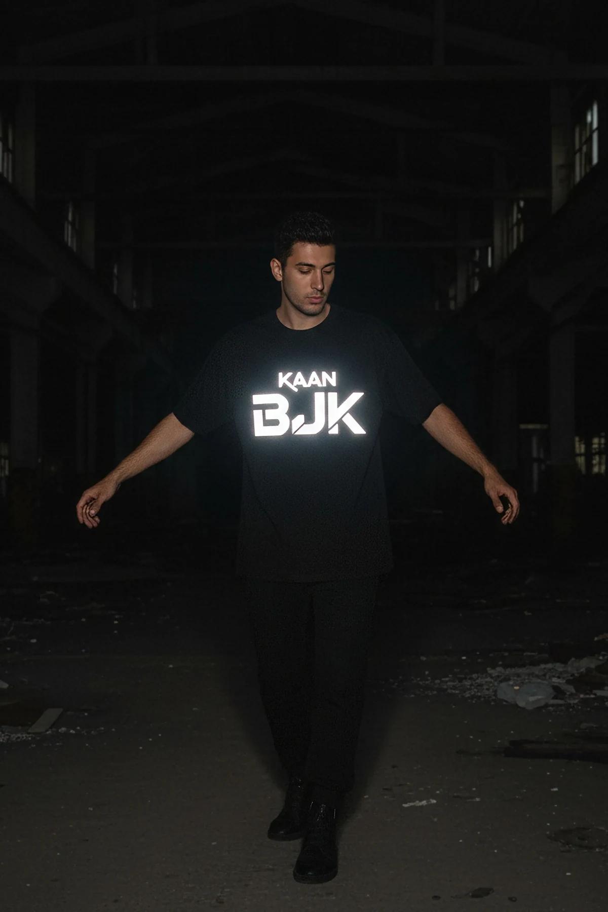 Düşük ışıkta göğüste beyaz parlayan büyük retroreflektör blok logo baskılı siyah oversize erkek tişört