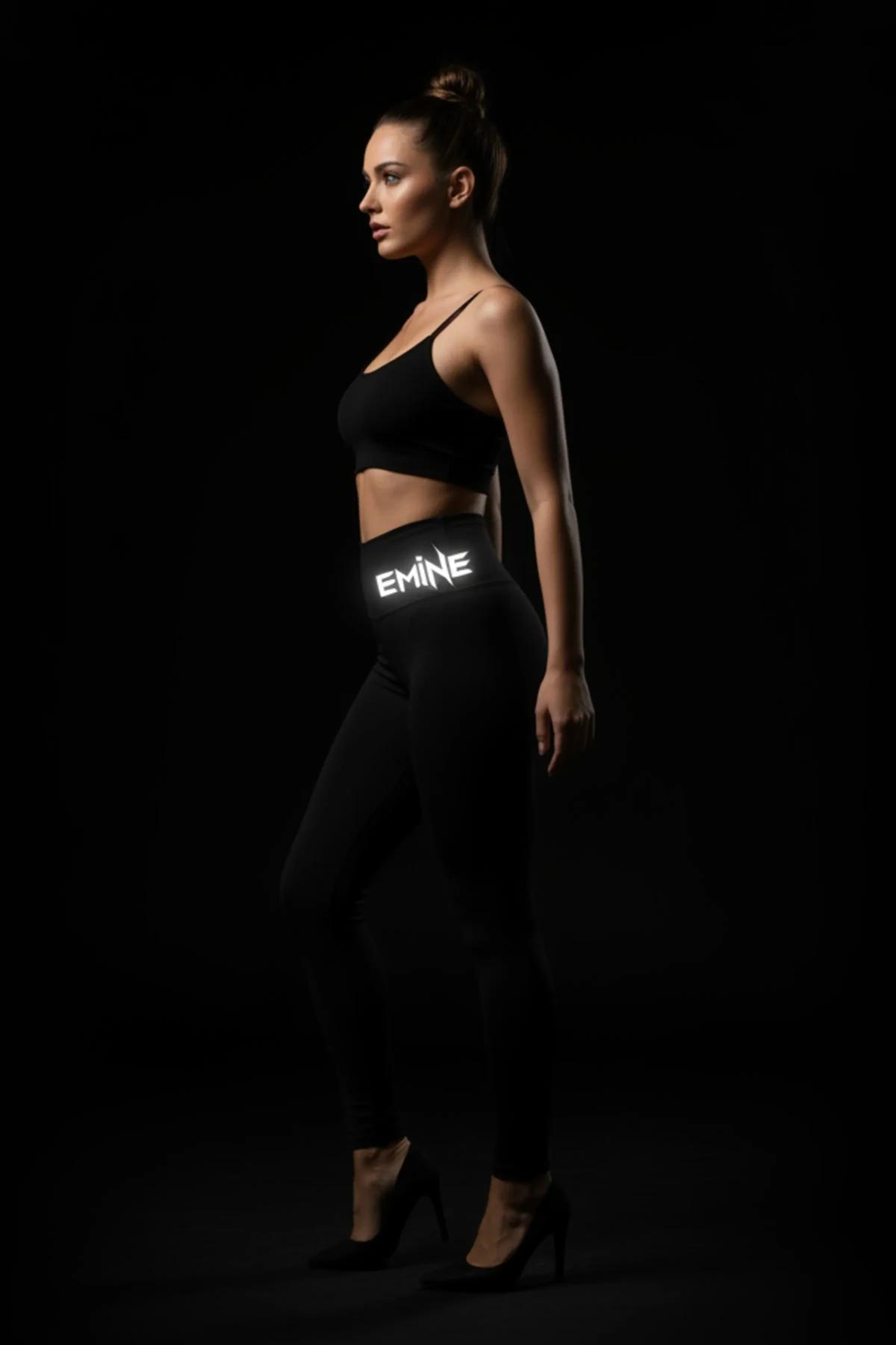 close-up of reflective EMİNE waistband print activated under flash on black leggings