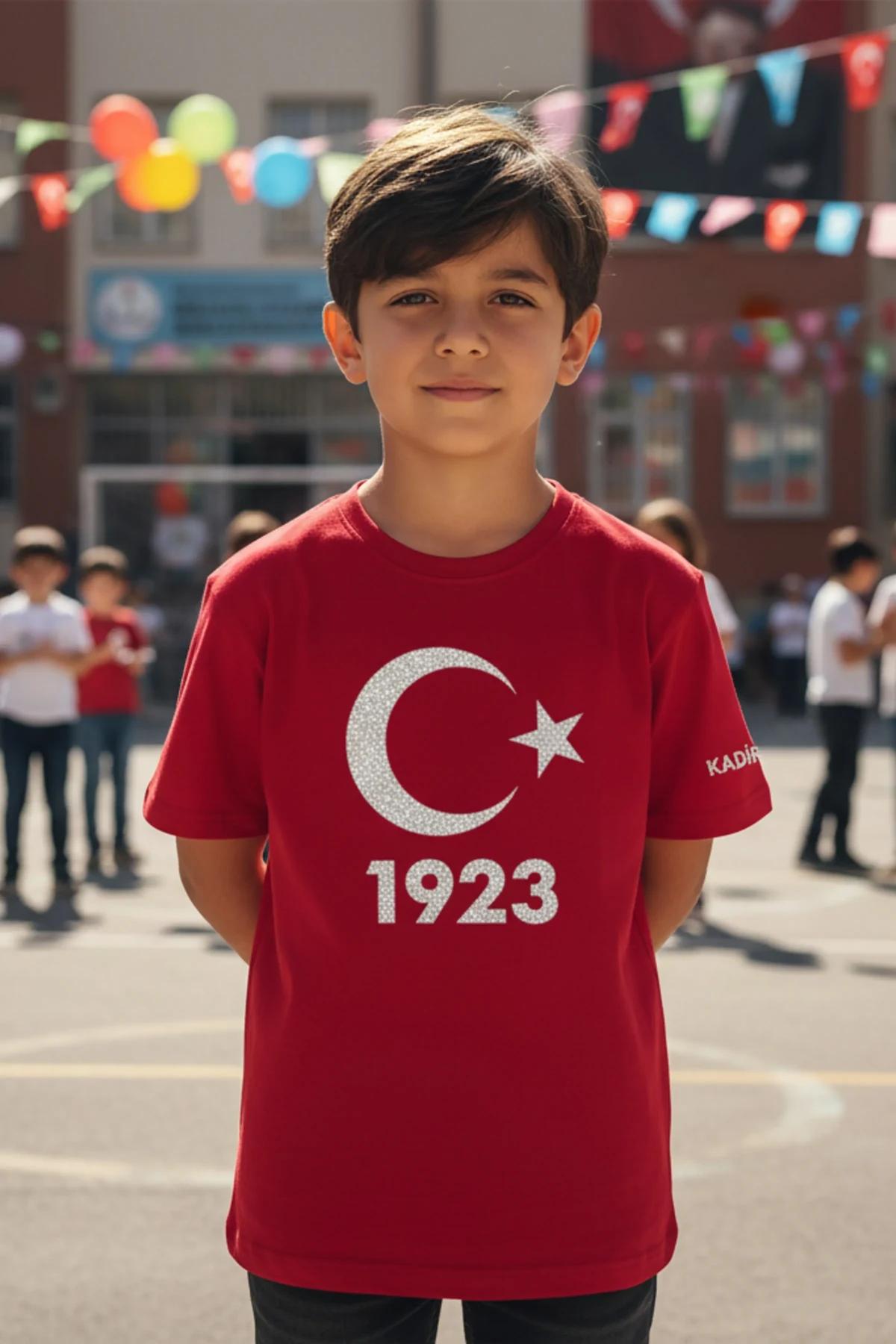 Sol kolda özel KADIR ismiyle, reflektör gümüş hilal yıldız ve 1923 baskılı kırmızı çocuk tişörtü, bir erkek çocuk tarafından giyilmiş