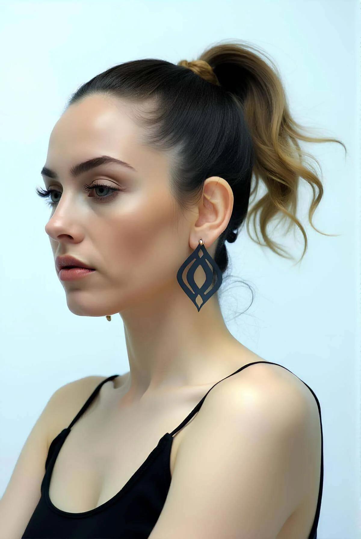 Mat siyah vegan deri sarkıt küpe, geometrik kesim motifi, yüksek at kuyruklu modelde