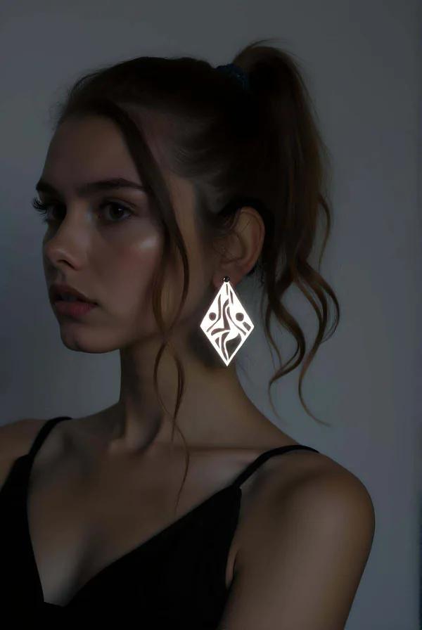 Gümüş reflektör geometrik iddialı küpe, tribal lazer kesim elmas şekli, topuz saçlı modelde