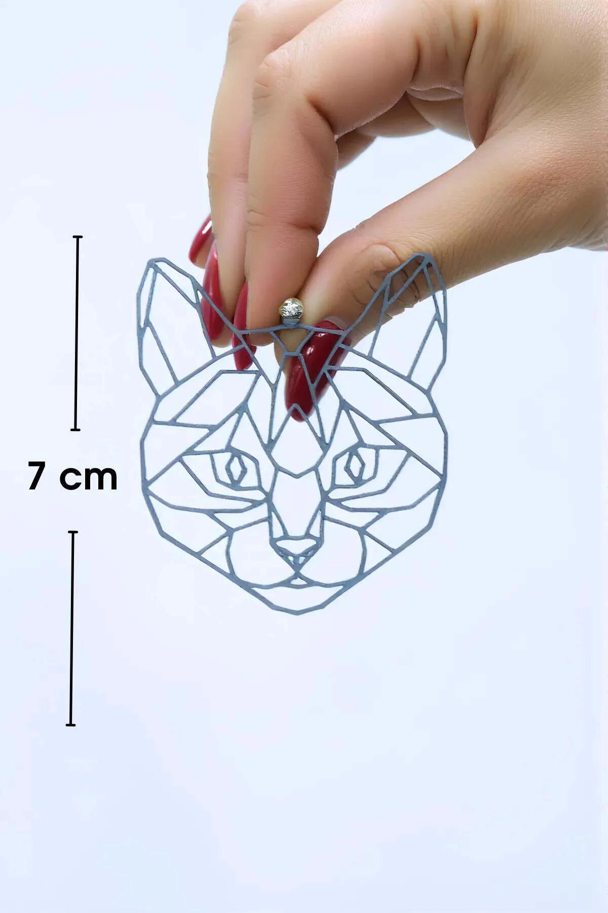 Az ışıkta camgöbeği ve pembe kırınım bantları gösteren lazer kesim geometrik kedi küpeler yakın çekim