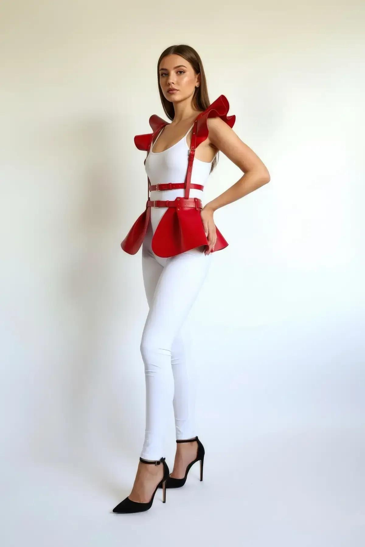 Kırmızı suni deri peplum harness etek, oversize fırfırlı omuz panelleri ve altın ton tokalar, beyaz kıyafet üzerinde
