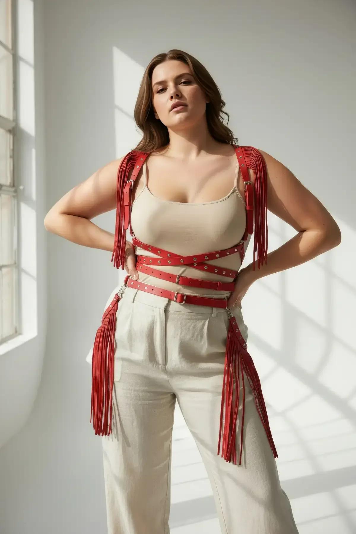 Büyük beden modelde bej bol paçalı pantolon ve krem kolsuz üst ile stilize kırmızı suni deri harness
