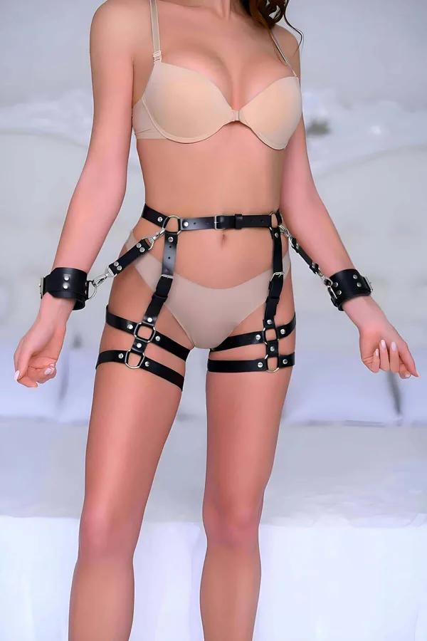 Çift bacak bandı, bel kemeri ve çıkarılabilir gümüş donanımlı bilek kelepçeli tam set olarak giyilen siyah suni deri uyluk harness