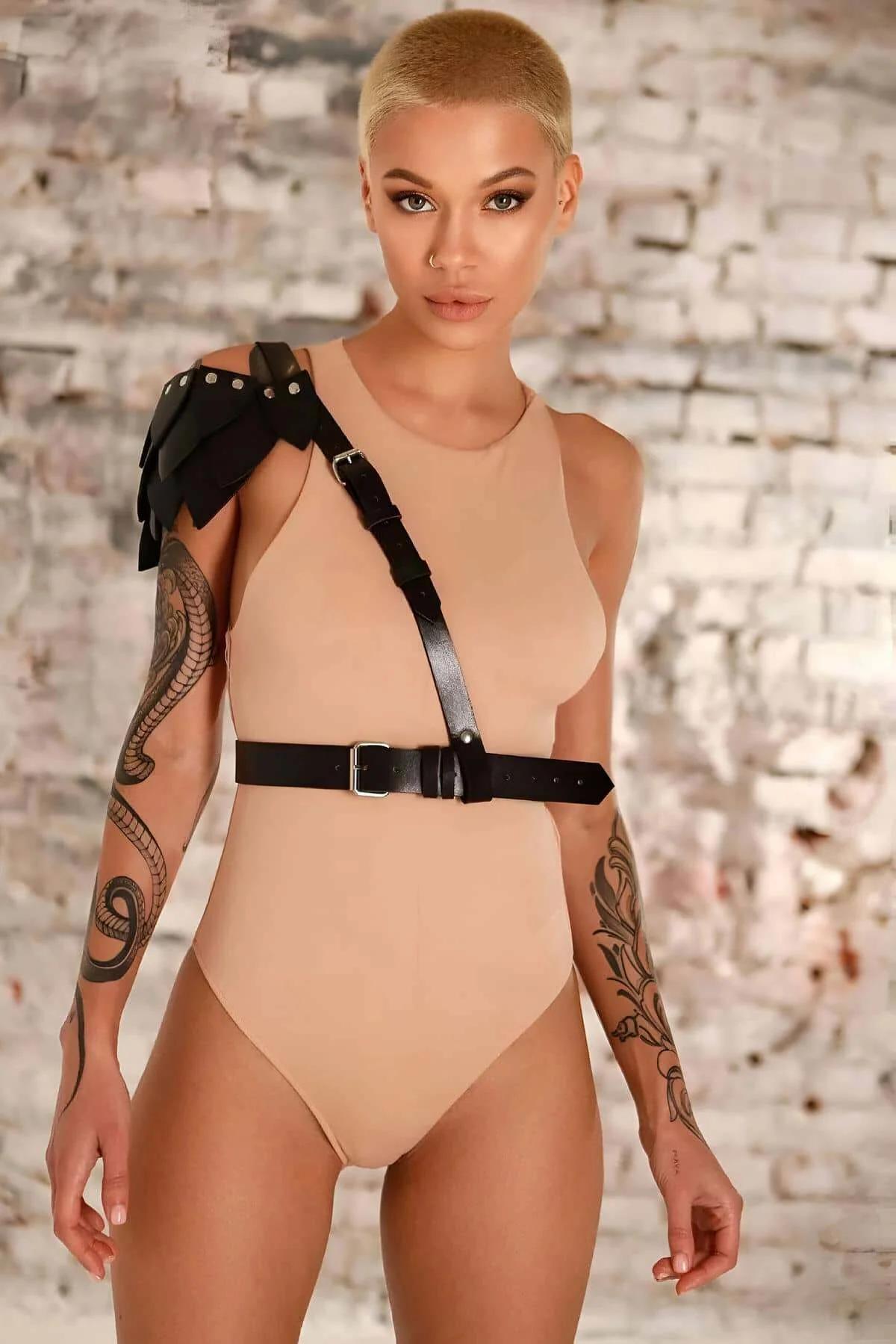 Siyah vegan deri tek omuz harness kemer omuzda katmanlı yaprak detayı ve gümüş metal toka ile