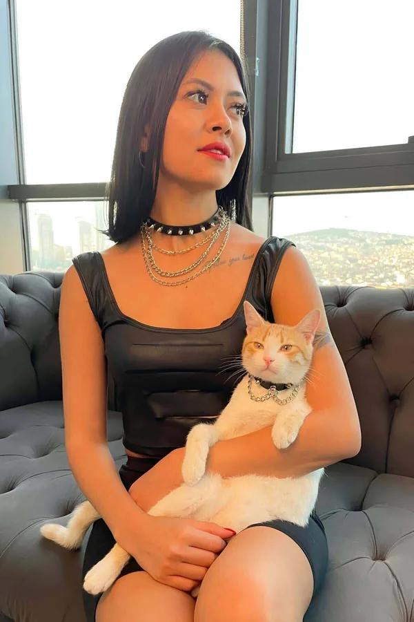 gümüş zincir kolyelerle katmanlanmış siyah suni deri sivri uçlu çoker, istiflenmiş boyun seti olarak takılmış