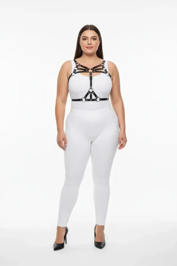 Gümüş O-halka donanımlı siyah suni deri askılı göğüs harness, beyaz crop top üzerinde katmanlı, büyük beden model