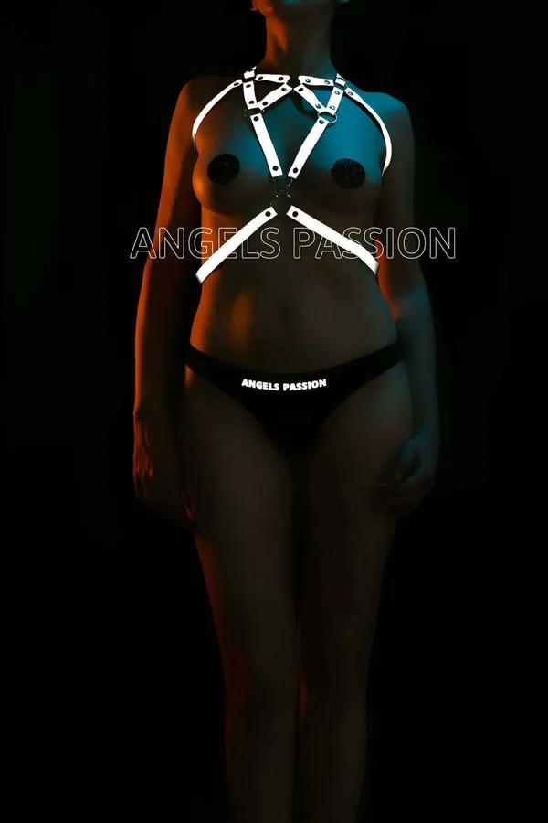 Neon aydınlatma altında parlayan gümüş O-halka donanımlı üçgen bant konfigürasyonlu beyaz reflektör göğüs harness