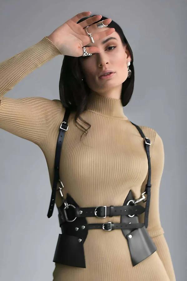 deve tüyü renkli nervürlü boğazlı kazak üzerine giyilen siyah suni deri oyma vücut harness, geniş bel panelleri ve gümüş tokalar