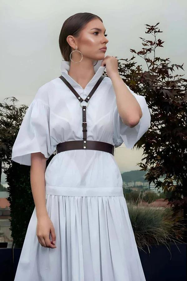 beyaz midi elbise üzerine giyilen espresso kahverengi suni deri göğüs harness, geniş bel kemeri ve gümüş zımba donanımı