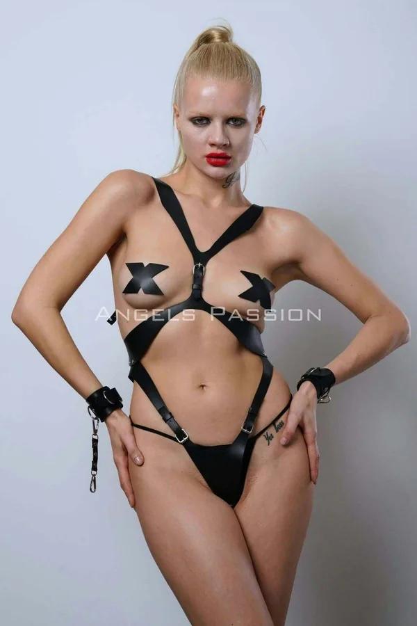 Çapraz göğüs X-askıları, gümüş tokalar, kalça bantları ve zincirli uyumlu bilek kelepçeli siyah vegan deri tam vücut harness