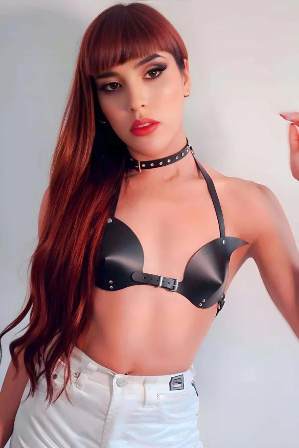 Beyaz kotla giyilen kalıplı kupalı, gümüş zımba süslemeli ve ön tokalı siyah suni deri sütyen harness