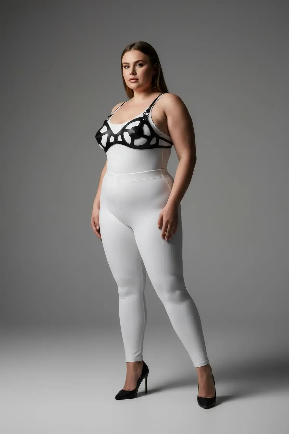 Beyaz bodysuit üzerinde organik oval kesimli siyah suni deri kafes sütyen harness, ön görünüm