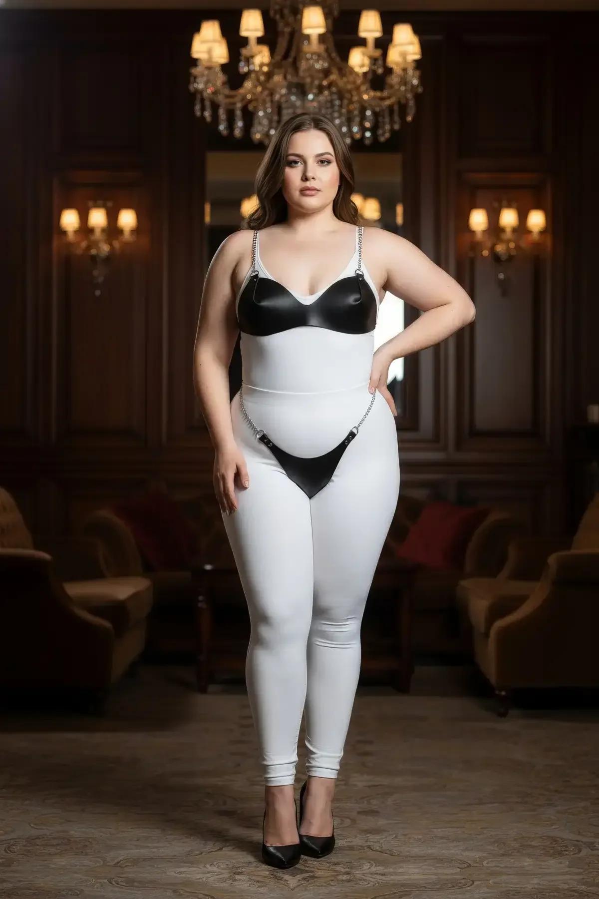 Modelde alçak oturuşlu, gümüş zincir vurgulu siyah suni deri kalça jartiyer harness