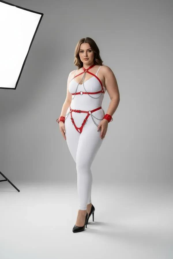 Beyaz bodysuit üzerinde gümüş O-halkalı ve sallanan bel zincirleri ile kırmızı suni deri tam vücut harness