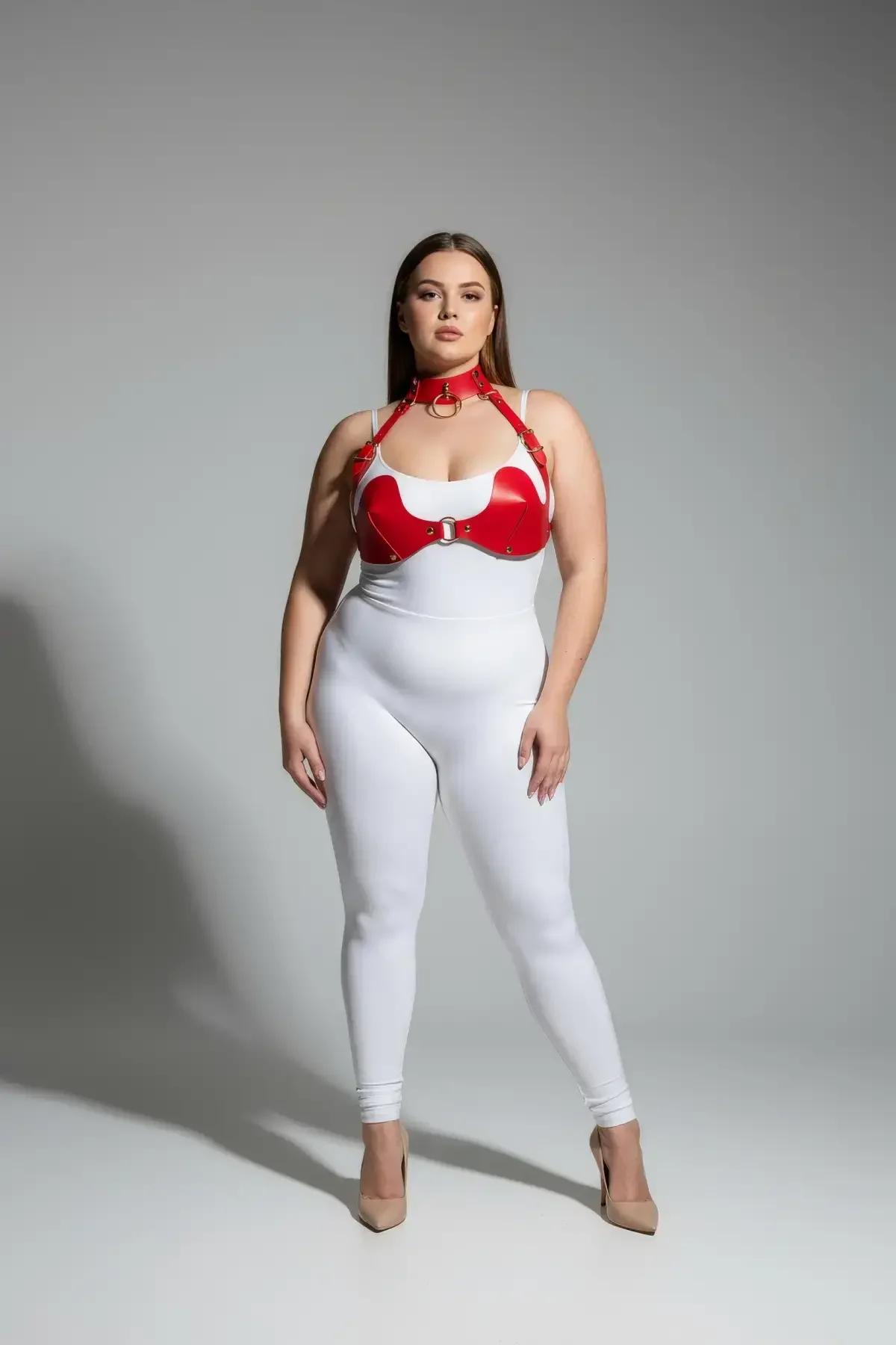 Beyaz body üzerine giyilmiş altın O-halkalı çoker ve sütyen fincan panelli kırmızı suni deri göğüs harness