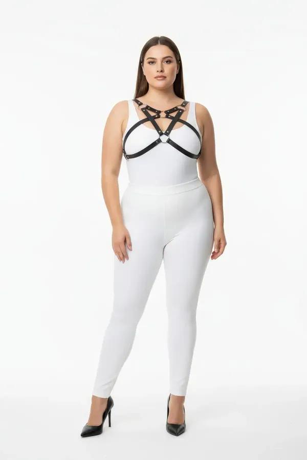 Geometrik çapraz askılar ve gümüş O-halkalı siyah suni deri göğüs harness, beyaz bodysuit üzerinde