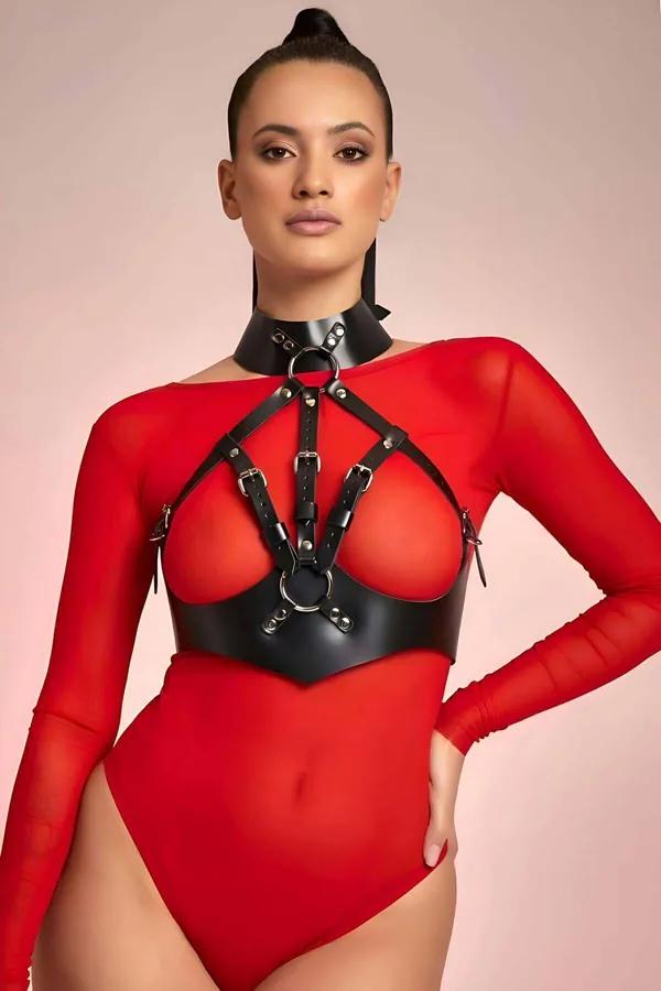 Kırmızı file bodysuit üzerine giyilmiş O-halkalar ve ayarlanabilir toka askılı siyah suni deri çok askılı halter boyun vücut harness'ı