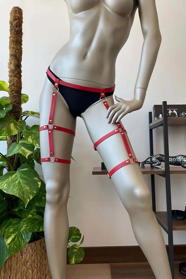 Manken üzerinde gümüş O-halkalar ve yığılmış askılı kırmızı suni deri ayarlanabilir uyluk harness
