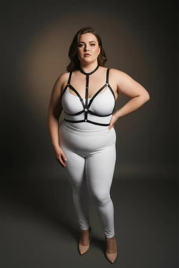 Gümüş O-halka detaylı ve çoker boyunluklu siyah suni deri bantlı vücut harness, beyaz bodysuit üzerinde