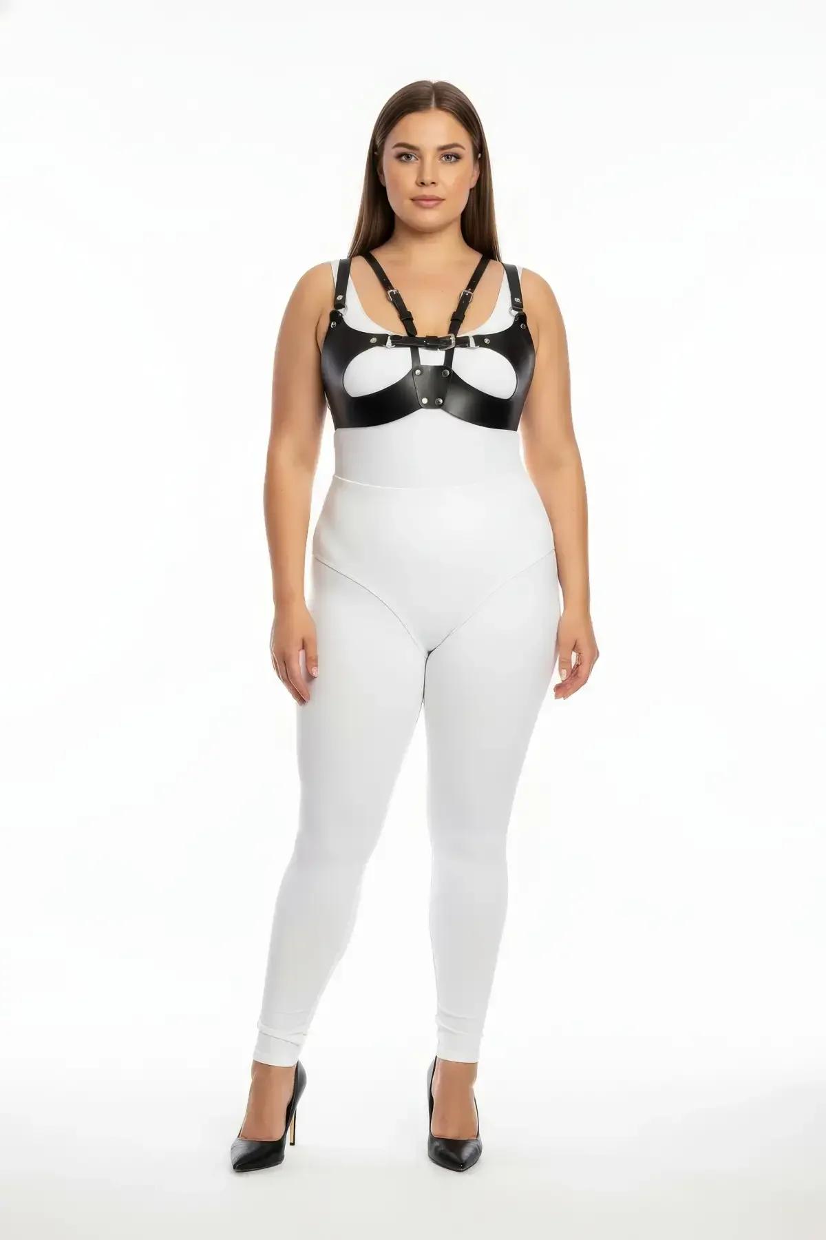 Gümüş O-halka merkezi detayı ve çok askılı ayarlanabilir çerçeveli siyah suni deri harness sütyen, beyaz bodysuit üzerinde