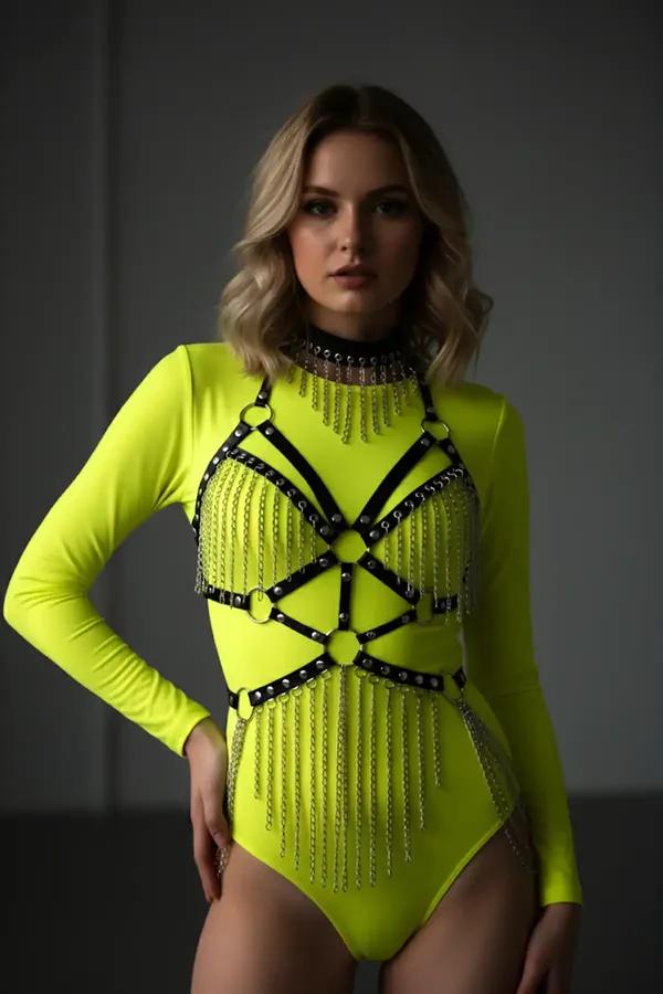 Neon sarı bodysuit üzerine giyilmiş kademeli gümüş zincir püskül ve O-halka konektörlü siyah suni deri vücut harness