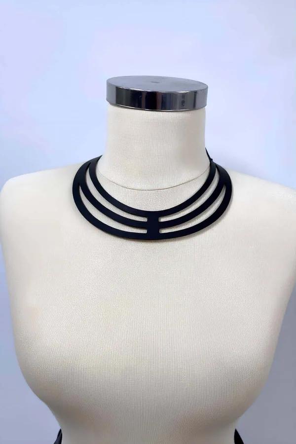 Manken üzerinde üç paralel bant ve merdiven kesimli köprülü siyah vegan deri çok askılı çoker harness
