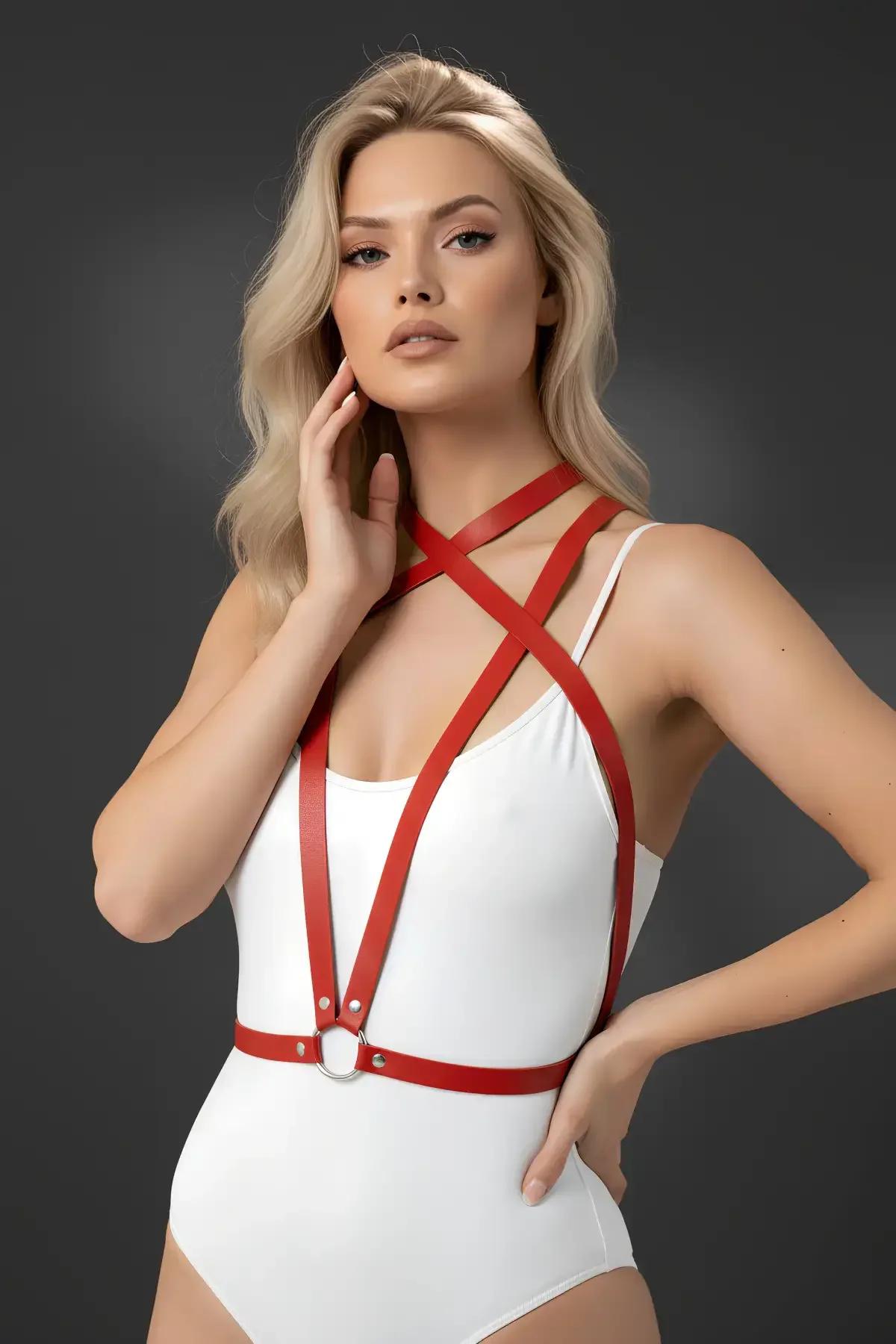 beyaz bodysuit üzerinde X-çapraz göğüs askıları ve gümüş O-halka bel bandıyla minimalist kırmızı suni deri vücut harness