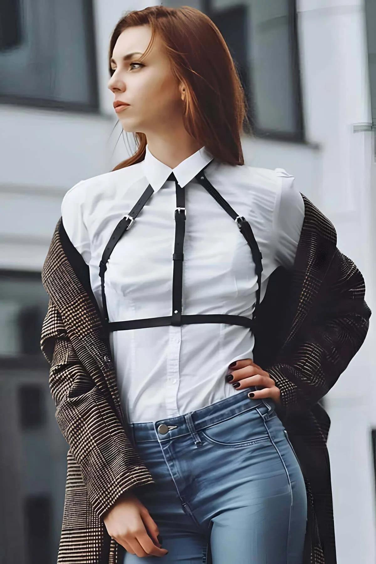 Siyah vegan deri göğüs harness askısında gümüş rengi pimli toka detayı yakın çekim