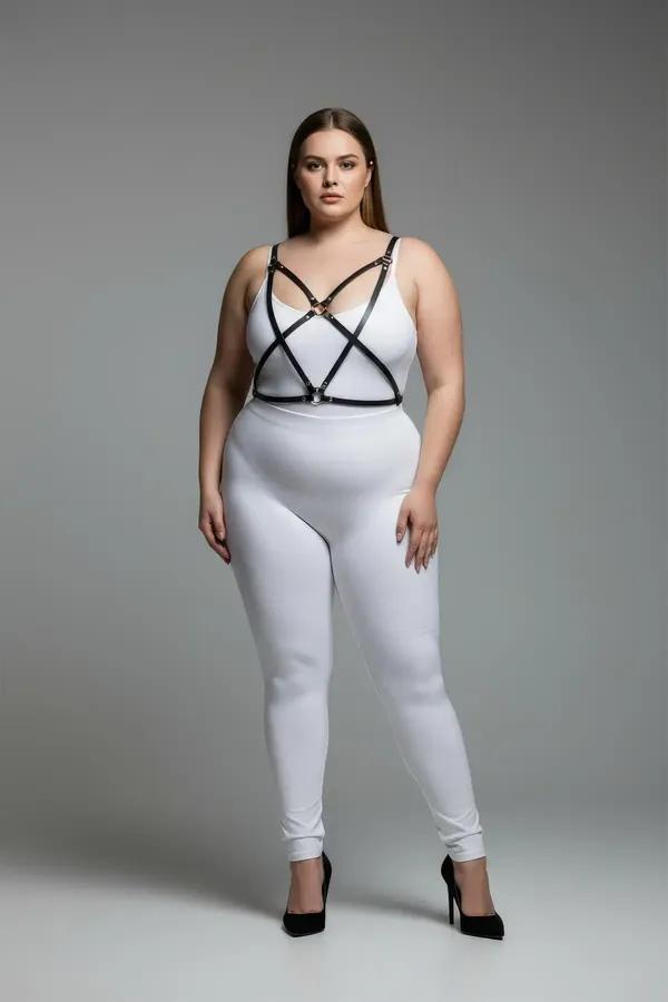 Beyaz bodysuit üzerinde X-çapraz bantlı ve gümüş O-halka aksesuarlı siyah suni deri kafes sütyen harness
