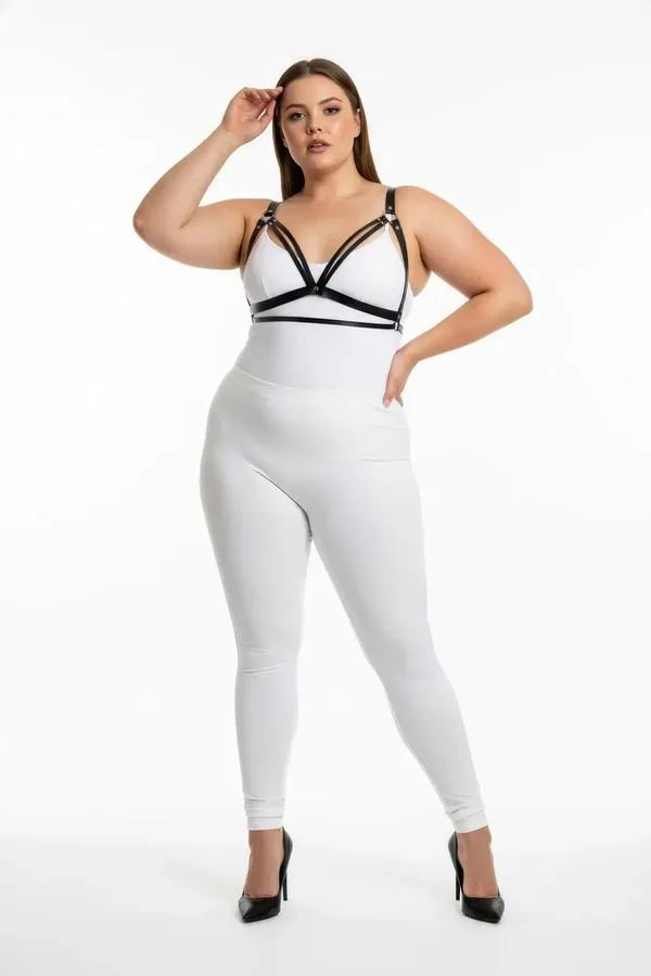 Beyaz crop top üzerine giyilen üçlü V-bant göğüs panelli ve gümüş tokalı siyah suni deri harness sütyen