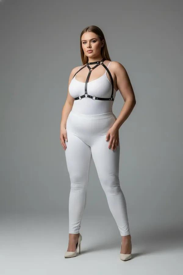 Beyaz bodysuit üzerinde gümüş O-halkalı siyah suni deri bantlı göğüs harness, ön görünüm