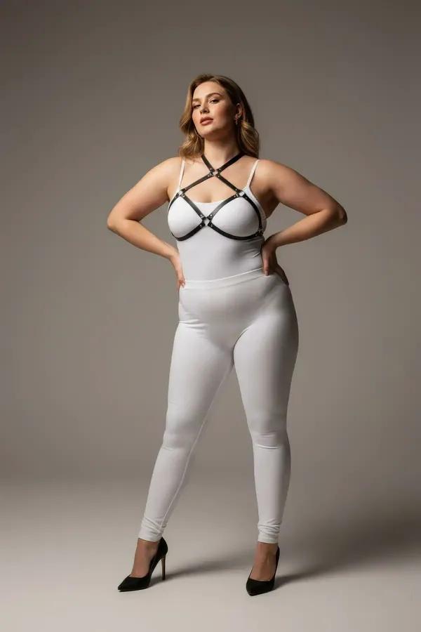 Gümüş metal konnektörlü ve dört çapraz kafes bantlı siyah suni deri O-halka göğüs harness, beyaz bodysuit üzerinde