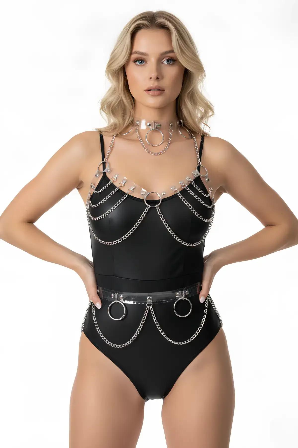şeffaf PVC ve siyah üzerine gümüş zincir O-halkalı 3 parçalı harness seti; suni deri bodysuit üzerinde