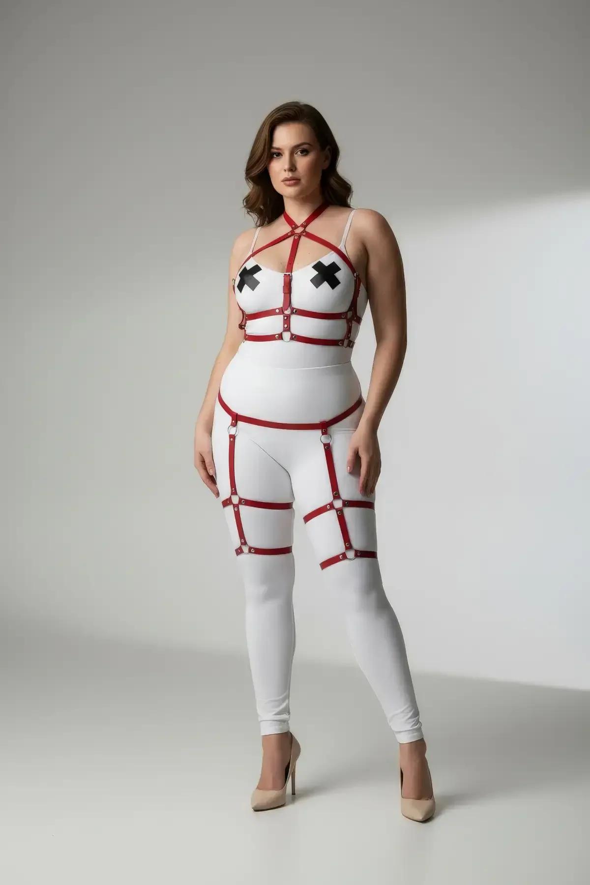 Beyaz body üzerine giyilmiş kafes bacak jartiyer ve gümüş O-halka donanımlı kırmızı suni deri askılı vücut harness