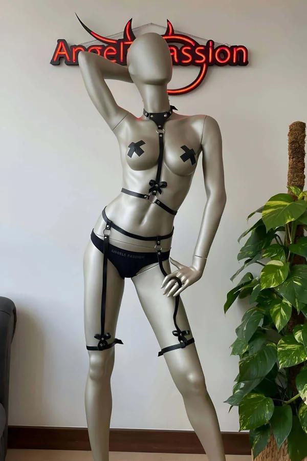 Saten fiyonk detayları, gümüş O-halkalar, boyunluk, göğüs harness, bel kemeri ve uyluk jartiyeleriyle siyah suni deri tam vücut harness seti