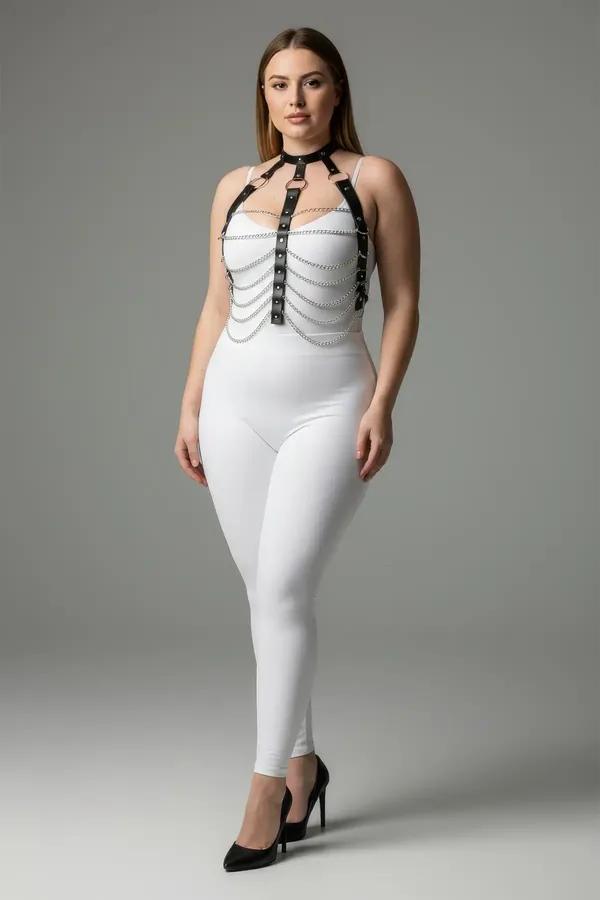 Beyaz bodysuit üzerinde beş sallanan gümüş zincirli ve metal zımba perçinli siyah suni deri göğüs harness