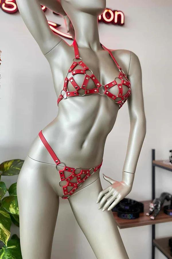 manken üzerinde gümüş O-halkalar ve zımbalarla kırmızı suni deri kafes harness sütyen ve külot seti