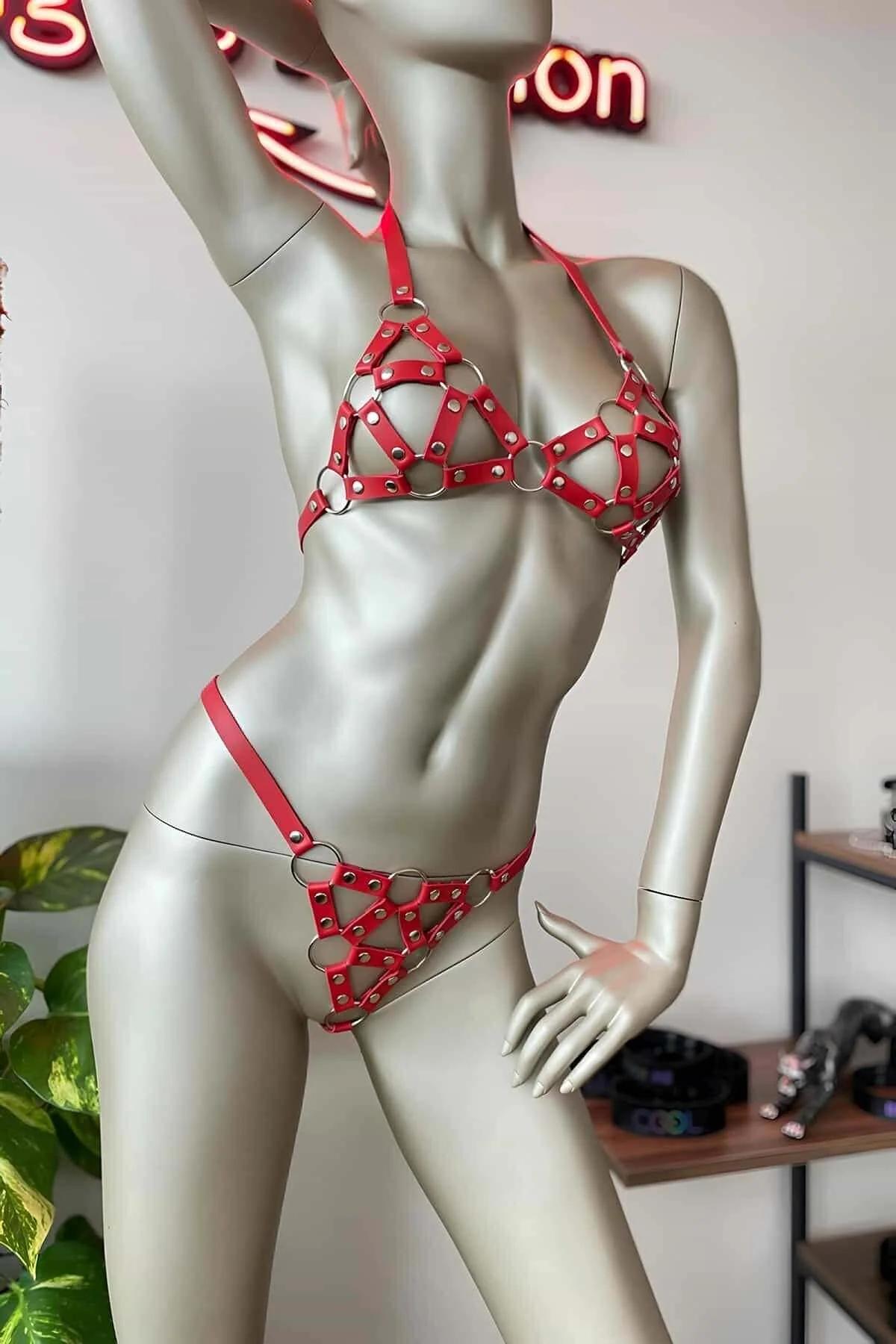 manken üzerinde gümüş O-halkalar ve zımbalarla kırmızı suni deri kafes harness sütyen ve külot seti