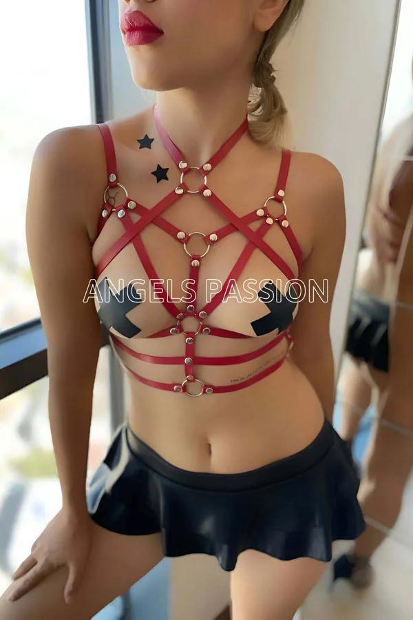 geometrik çapraz göğüs askılarında gümüş O-halkalar ve kubbe başlı perçinlerle kırmızı suni deri yıldız patlaması vücut harness