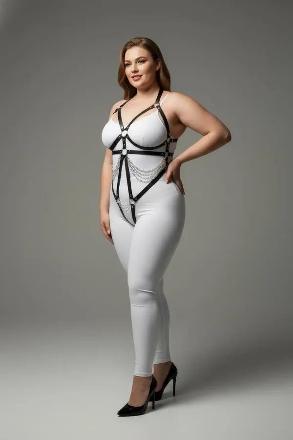 Beyaz bodysuit üzerinde gümüş O-halkalı ve sallanan zincir süslemeli siyah suni deri sütyen altı harness