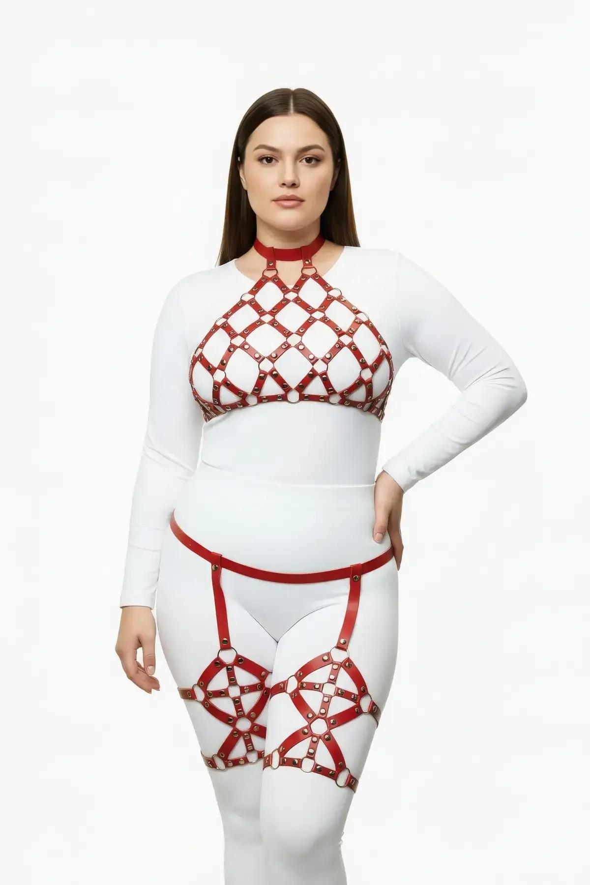 Beyaz kıyafet üzerine giyilen elmas ızgara göğüs paneli ve altın tonlu O-halka perçinli kırmızı vegan deri kafes halter harness ve jartiyer seti