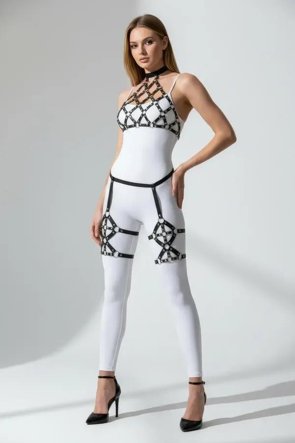 Beyaz bodysuit üzerinde göğüste altın O-halkalar ve gümüş kafes uyluk parçalarla siyah suni deri kafesli büstiyer harness seti