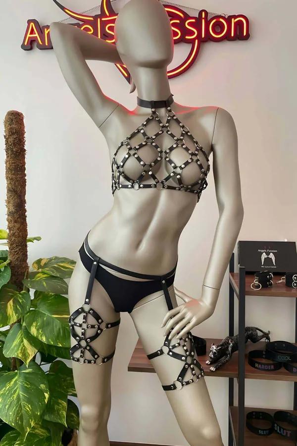 Manken üzerinde gümüş kubbe perçinli ve eşleşen uyluk jartiyer bantlı siyah suni deri zımbalı kafes halter harness